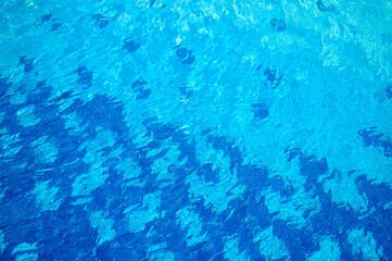Blue water texture with light reflection. Water surface with rings and ripples, splashes and bubbles