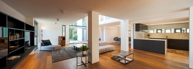 Modern living room with large sofa, pouf, central coffee table, above a large carpet. Interior of a...