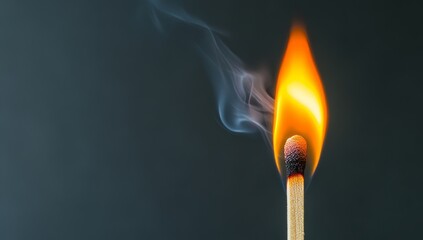 A close-up of the burning tip of an unlit match, with smoke rising from it against a dark background.
