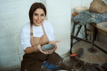Female work for small craft handmade kitchenware business in workshop