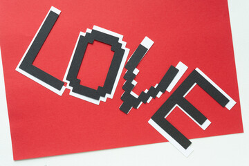 pixel font sign with the word love on red and white paper