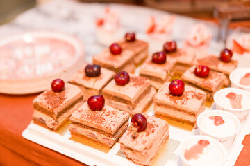 Petit fours on a tray made with chocolate and cherries.