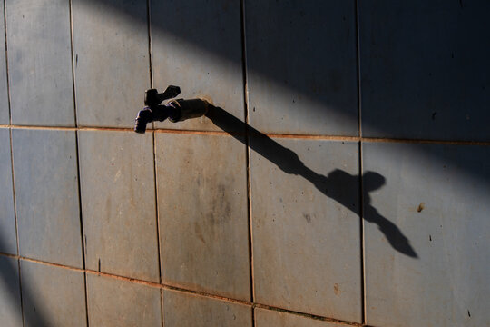 A public water tap for ablution with its shadow on the wall