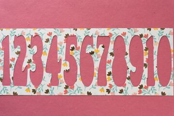 machine-cut stencil with numbers (cutouts) on pink