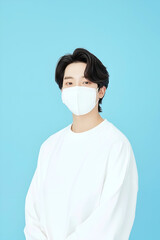 Young Man Wearing a Protective Face Mask for Health Safety in Minimalistic Setting