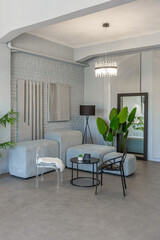 stylish discreet interior of the sleeping area in a modern studio in white-gray colors with green plants. daylight and no people inside