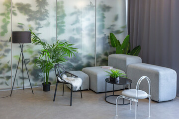 a spectacular area with a table and chair against the backdrop of a transparent designer partition behind which there are plants