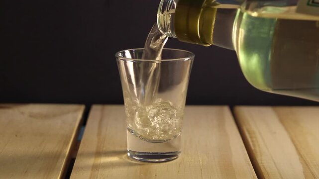 Isolated glass cup beeing filled by a cacha&ccedil;a (Brazilian traditional alchoolic drink)
