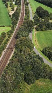aerial view of car driving alongside a traintrack