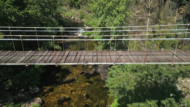 Drone shot of a wooden bridge of Ponte Colgante de Calvelo in Rio Lerez, Pontevedra, Spain.