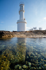 Formentera, faro de la Savina, en el puerto  de la isla, fotografiado en marea baja