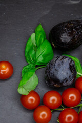 Juicy, aromatic, bright cherry tomatoes, sun-dried basil and figs on a black stone plank. Copy space the text. Banner. Background