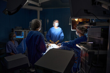 Obraz premium Doctors in protective masks doing operation in the operating room in hospital