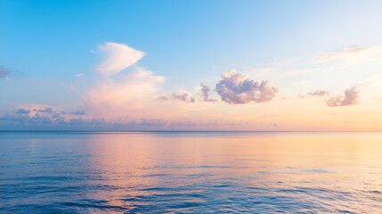 Obraz premium A serene ocean view at sunset with colorful clouds reflecting on the calm water, perfect for relaxation and inspiration.