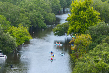 Aftermath of hurricane Debby flooding natural disaster. Kayak boats floating on flooded street...