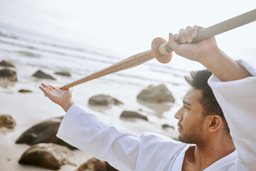 Martial arts, beach and man with weapon for training, practice and learning aikido, karate and jiujitsu. Sports, nature and person with bokken by ocean for fitness, exercise and workout for taekwondo