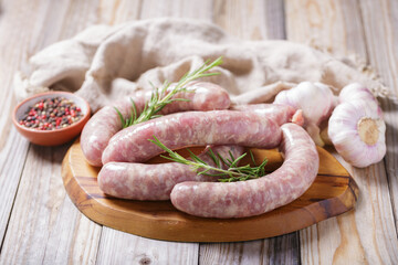 Fresh sausages with rosemary and ingredients for cooking