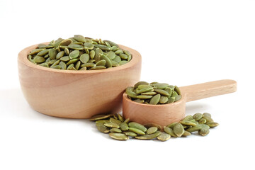 Pumpkin seed in wooden bowl and spoon close up on white background.