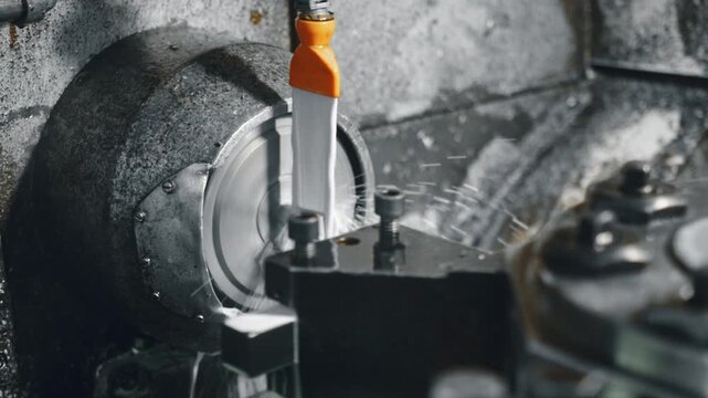 Witness high-precision metal cutting with an industrial cnc lathe machine in action. Experience the intricate cutting process and coolant application in an industrial workshop setting