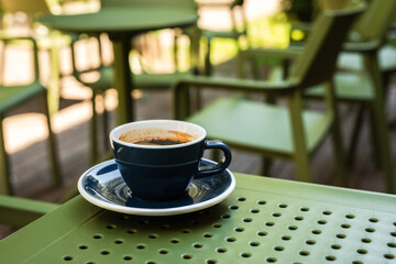 A cup of black coffee on a cafe terrace