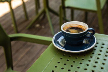 A cup of black coffee on a cafe terrace