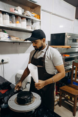 Skilled chef decorates cake in modern kitchen with precision and attention to detail