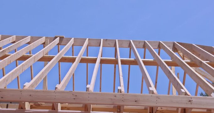 Wooden roofing truss frame is installed by house under construction roof