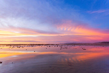Fototapeta premium amazing colorful cloud in sunset above Pling island at Naiyang beach Phuket. A peaceful twilight scene featuring a stunning gradient sky transitioning from deep purple to warm orange as night falls.