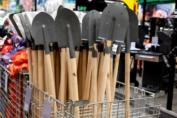 Shovels with wooden handles in a hardware store display.
