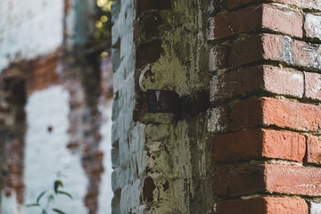 An old brick wall with a piece of iron sticking out of it