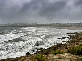 Even on a stormy summer morning, a handful of people explore the beach, Short Sands, York, Maine