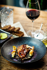 Corn chicken supreme. Beluga lentils, Old Ammerlander cheese, mini zucchini, red wine sauce. Delicious healthy traditional food closeup served for lunch in modern gourmet cuisine restaurant