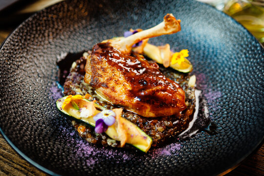 Corn chicken supreme. Beluga lentils, Old Ammerlander cheese, mini zucchini, red wine sauce. Delicious healthy traditional food closeup served for lunch in modern gourmet cuisine restaurant