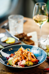 Warm salad with Argentinian king prawns. Almond potato, mini romaine lettuce, carrot, cherry tomato, pesto, black root chips, caramelized walnut, beet balsamic. Food served in modern restaurant