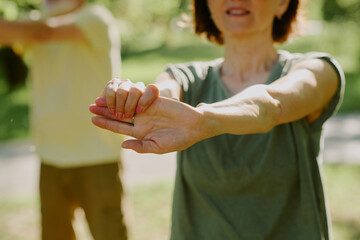 Medium close up of female manicured hands during arm muscle stretch exercise
