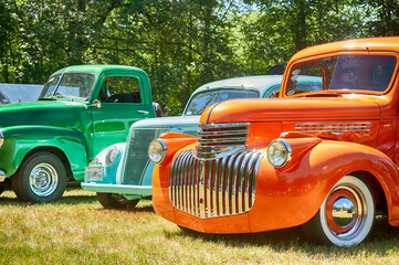 Colorful vintage vehicles on display at show in park.
