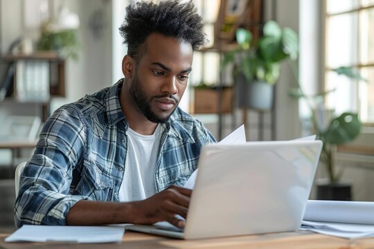 Beautiful man reading agreement of cancellation policy on laptop screen over wooden desk at office.