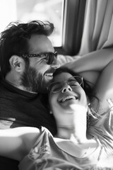 Fototapeta premium Two people sitting together, smiling, with arms around each other on a sunny day.