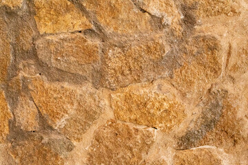 A close up of a rustic stone wall with natural variations in color and texture