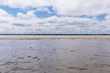 Confluence of two dark and light waters of the Amazon River with the Nanay River.  In the Amazon...
