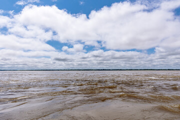 Confluence of two dark and light waters of the Amazon River with the Nanay River.  In the Amazon...