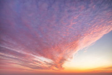 A beautiful sky tinted by the sun leaving vibrant shades of gold, pink, blue and multicolored. Clouds in the twilight evening and morning sky. Cloudy sky background in the evening and during the day.