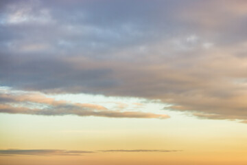 A beautiful sky tinted by the sun leaving vibrant shades of gold, pink, blue and multicolored. Clouds in the twilight evening and morning sky. Cloudy sky background in the evening and during the day.