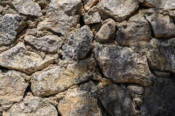 light and shadow on a wall made of real stone close-up