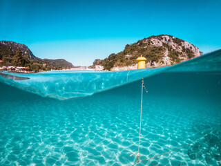 Over under of a white sand beach and a blue sky in palaiokastritsa beach, Corfu island,Greece