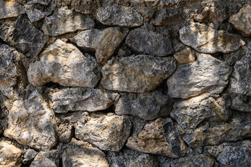 wall made of real stone close-up light and shadow