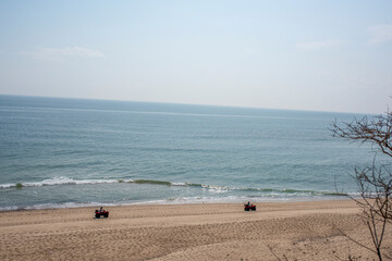 two people ride along the beach in cape cod