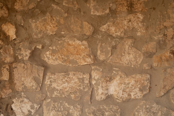 A close up of a weathered stone wall The texture is rough and uneven showing the passage of time