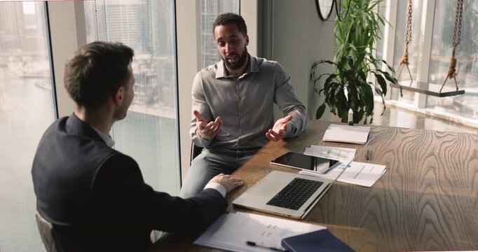 After productive discussion, multiethnic colleagues celebrate successful agreement or achievement with high five gesture, express mutual satisfaction, camaraderie and acknowledgment of job well done