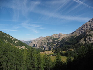 Alpine stream flowing through a green valley with rocky mountain peaks